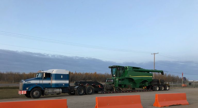Fardier transportant une moissonneuse