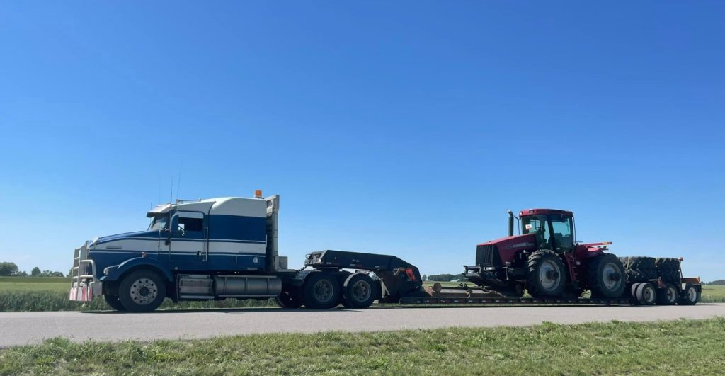 Fardier d'Excavation P. Huot transportant un tracteur